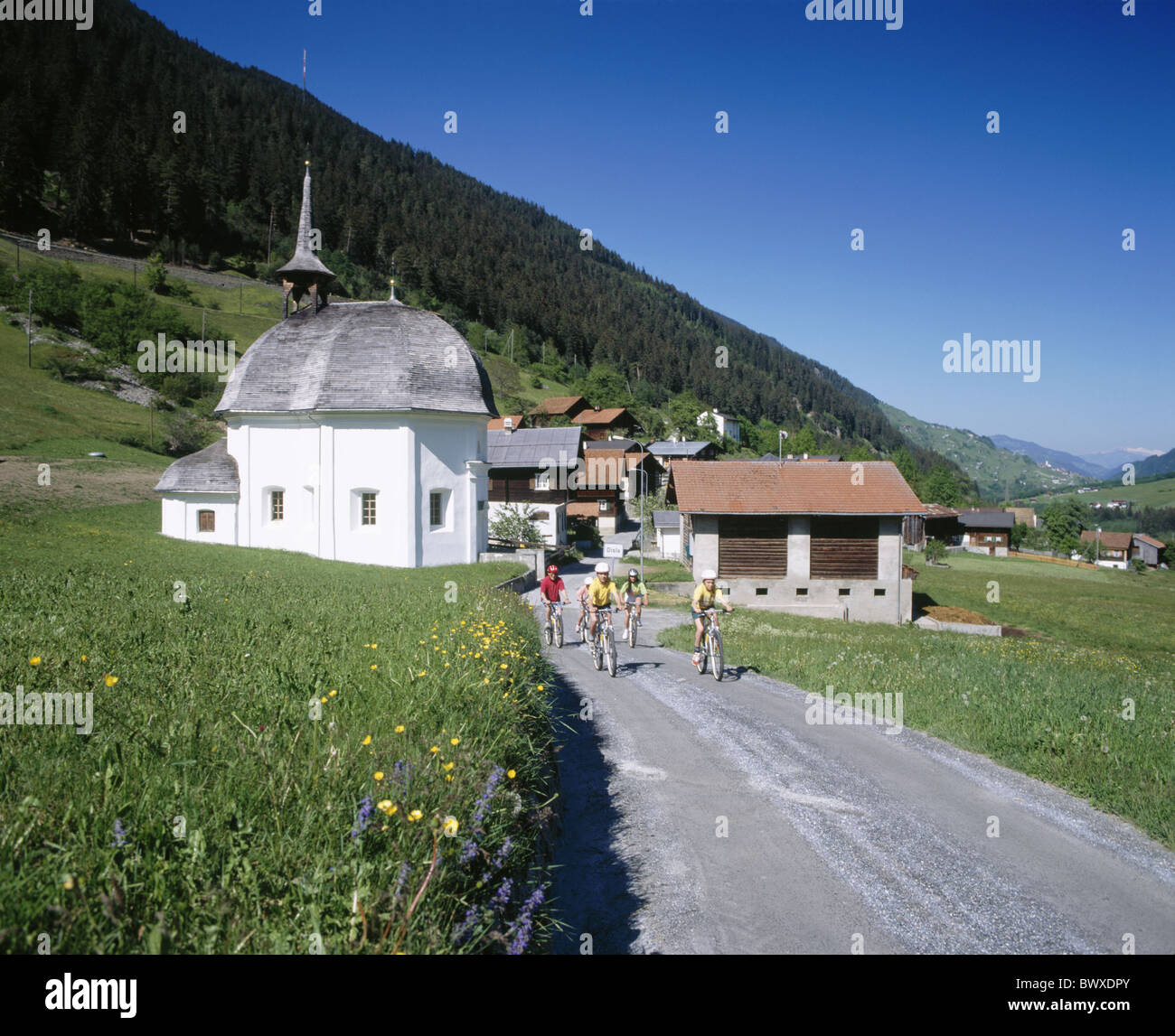 Village Family Country Lane Graubunden Grisons grupo iglesia bicicleta de montaña suiza Europa para superdotados de Surselva rid Foto de stock