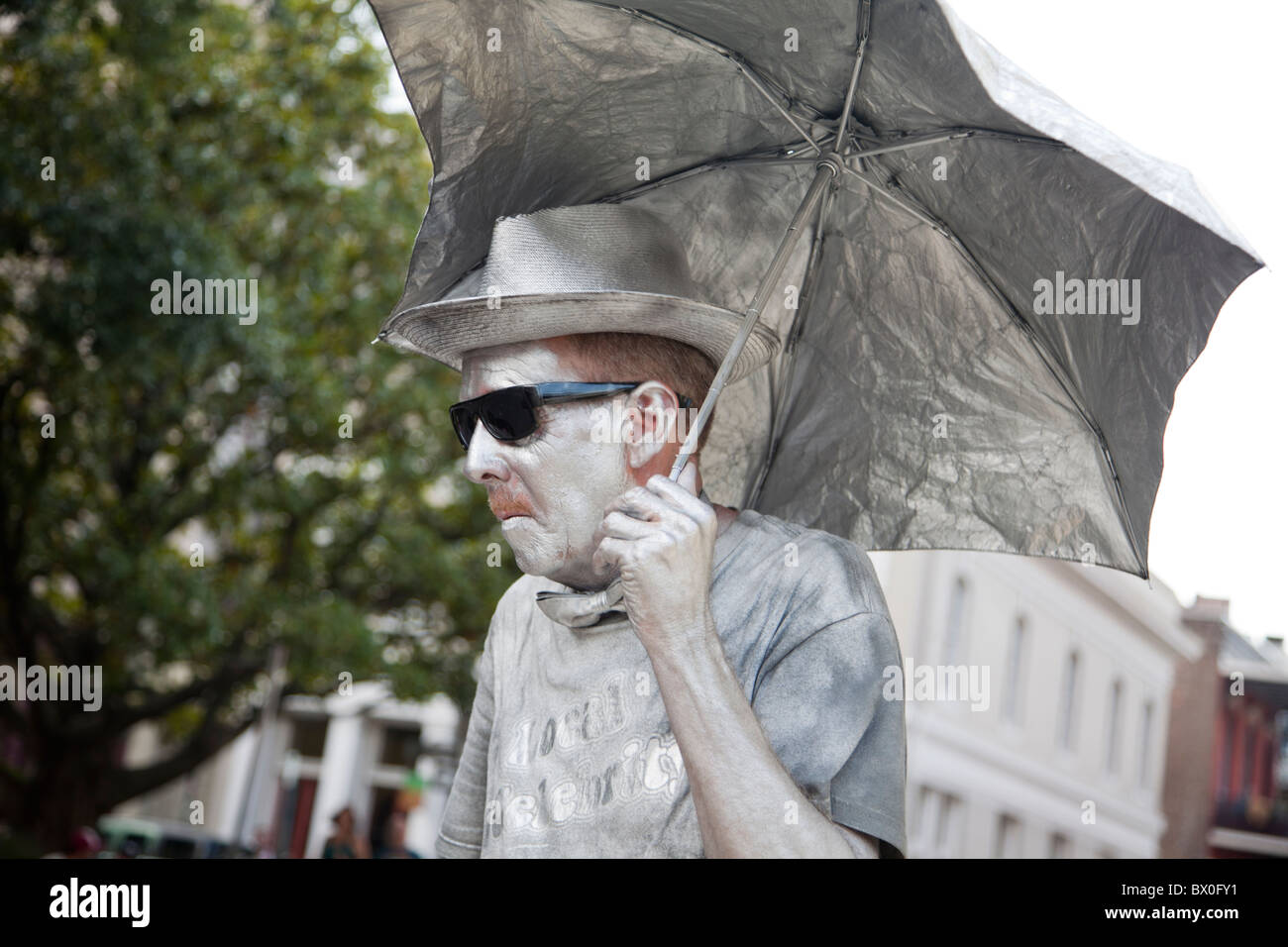Un hombre, pintado en plata y quieta como una estatua, realiza para consejos en New Orleans, Louisiana. Foto de stock