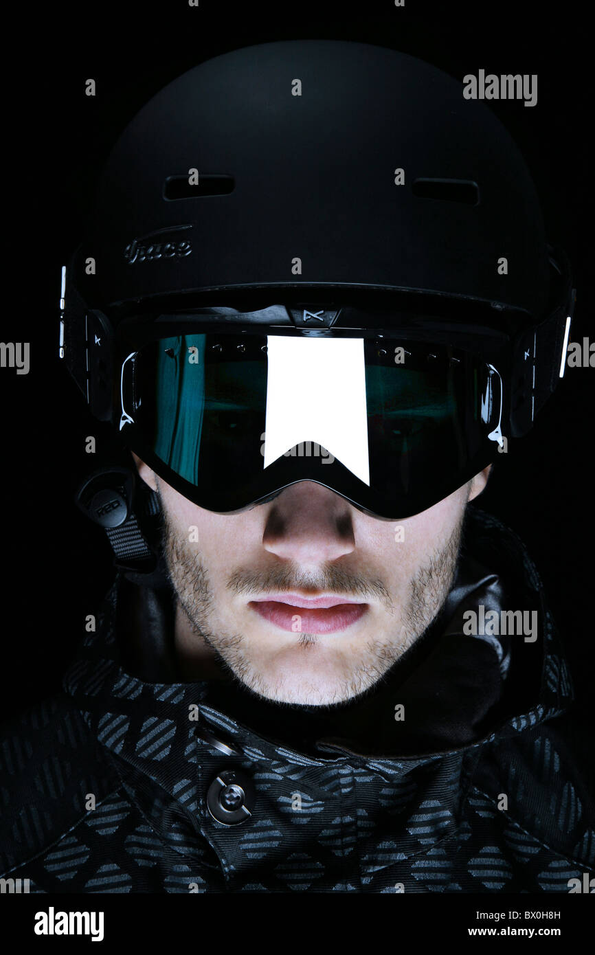 Pequeño niño en ropa de esquí, cascos y gafas, listo para ir a esquiar con  la caída de nieve Fotografía de stock - Alamy