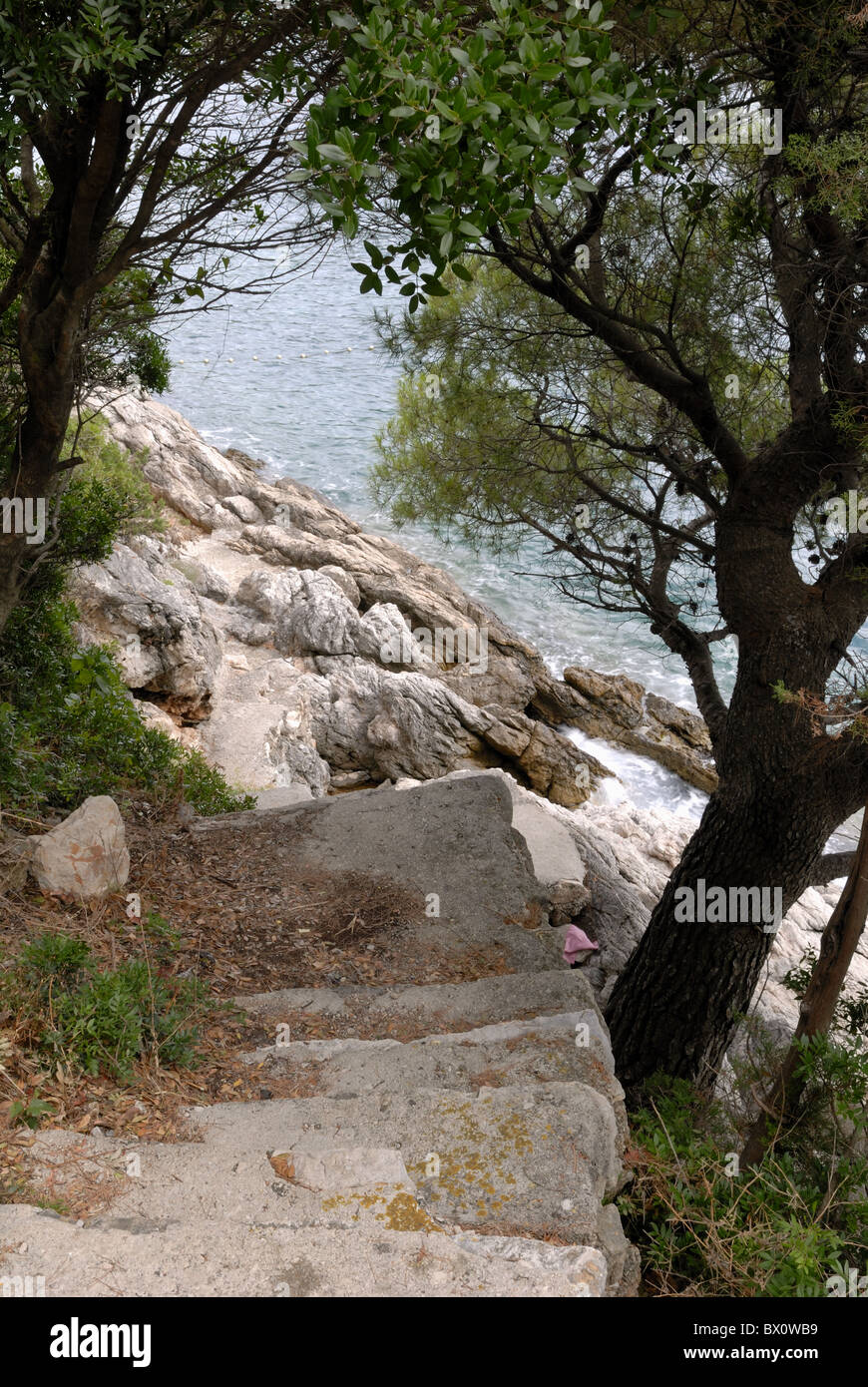 Hay una serie de pasos para ayudar a las personas a entrar y salir de la playa rocosa en la bahía de Lapad. Setaliste Nika I Pucica Meda, de Lapad de Dubrovnik,... Foto de stock