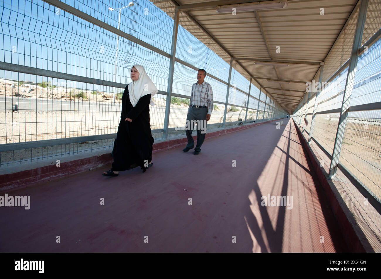 Los palestinos caminar a través de una jaula que se extiende desde la terminal de Erez de Israel a Gaza. Foto de stock