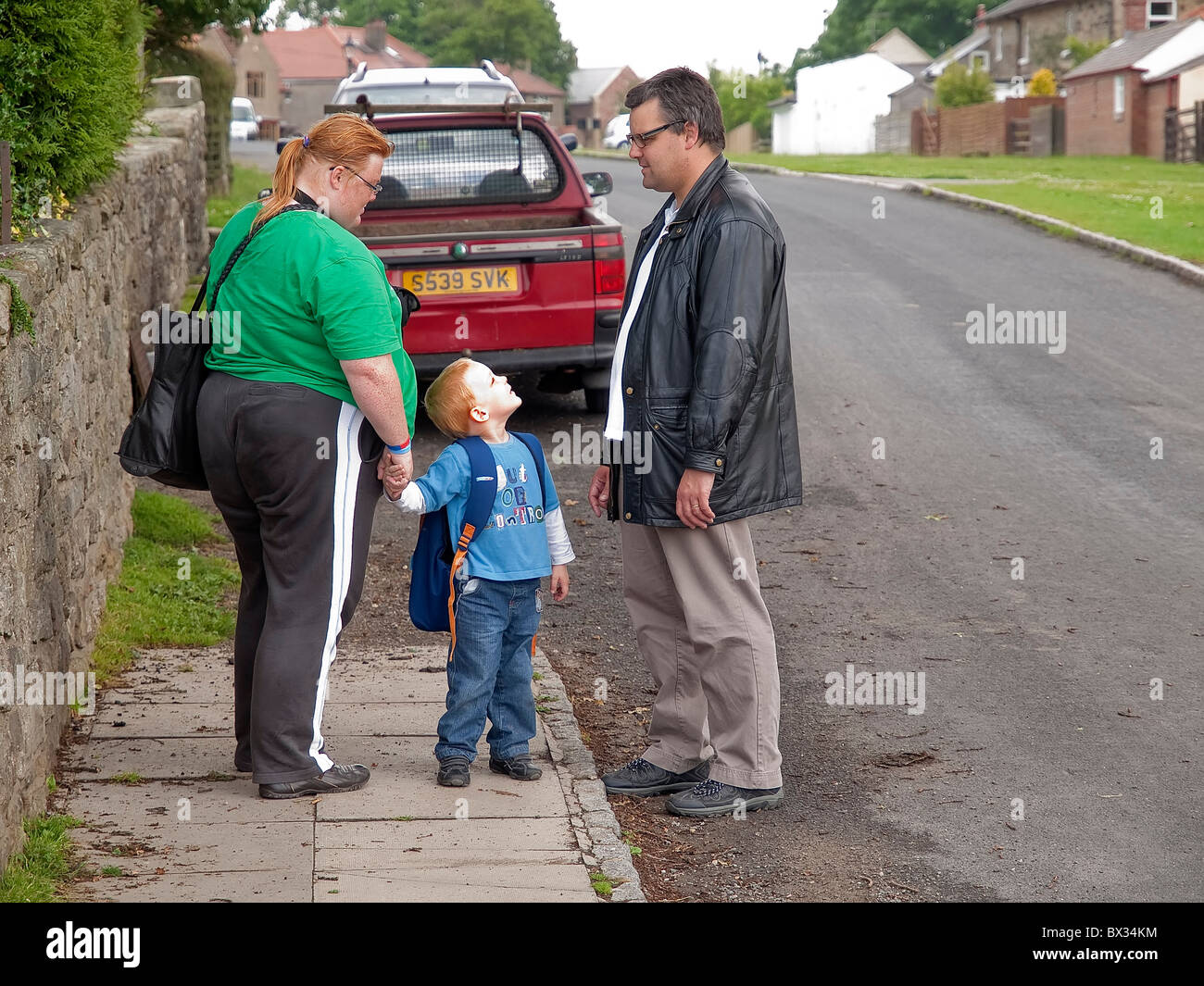 La Familia Real mamá papá niño cabello rojo auburn jengibre representada en calle residencial Foto de stock