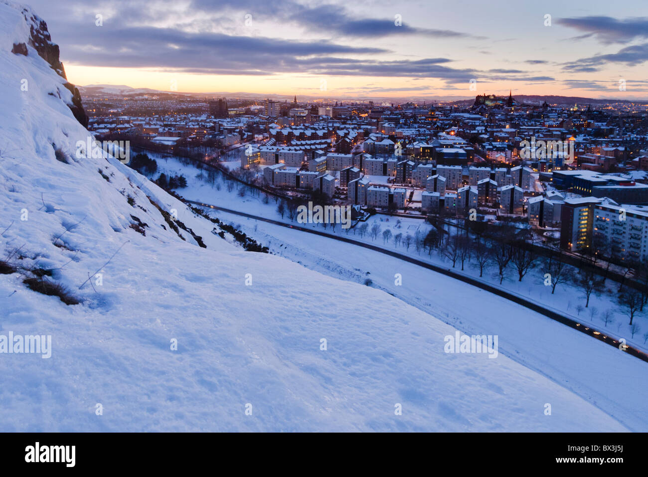 Mirando por encima de una nevada Edimburgo al atardecer en el castillo de Salisbury Crags Foto de stock