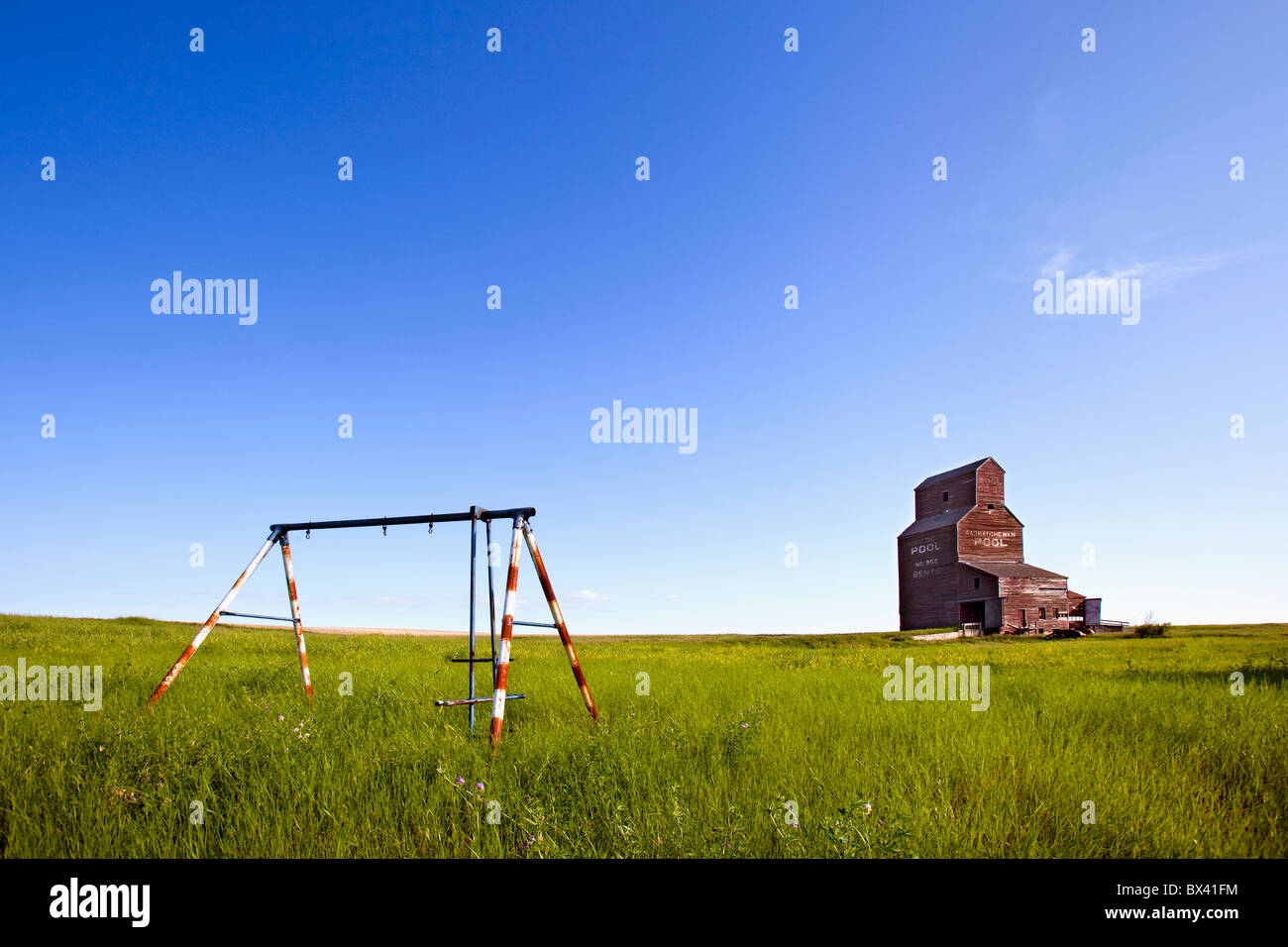 Un viejo columpio con un elevador de grano detrás de ella en una ciudad  fantasma, Doblas, Saskatchewan, Canadá Fotografía de stock - Alamy
