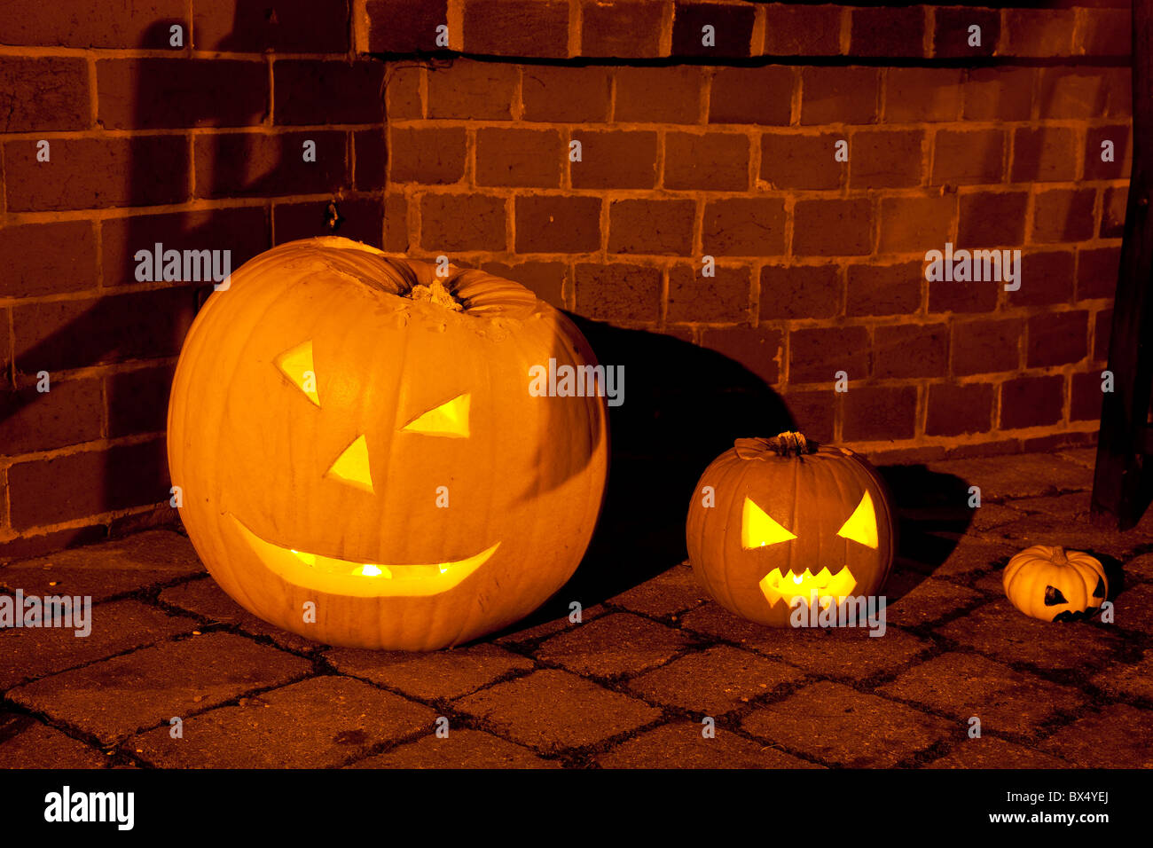 Tres calabazas, pequeños, grandes y pequeños, en la noche de Halloween Foto de stock