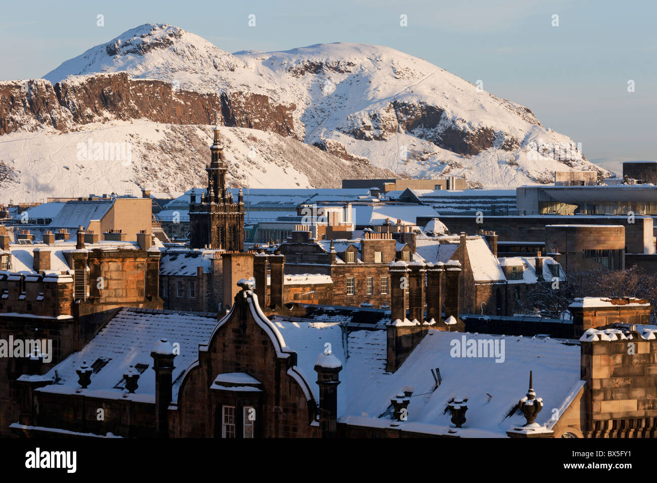 Vistas a la parte vieja de Edimburgo desde el castillo de explanada para Aurthurs Asiento, cubiertos de nieve en el sol de la mañana Foto de stock