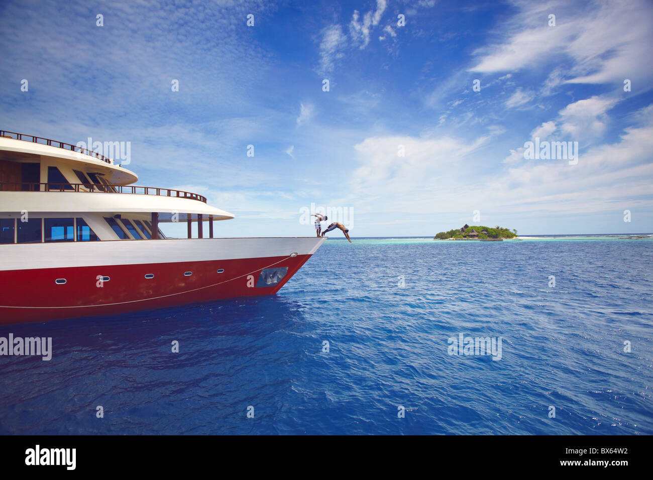 Los jóvenes saltando de un barco en el mar, Maldivas, Océano Índico, Asia Foto de stock