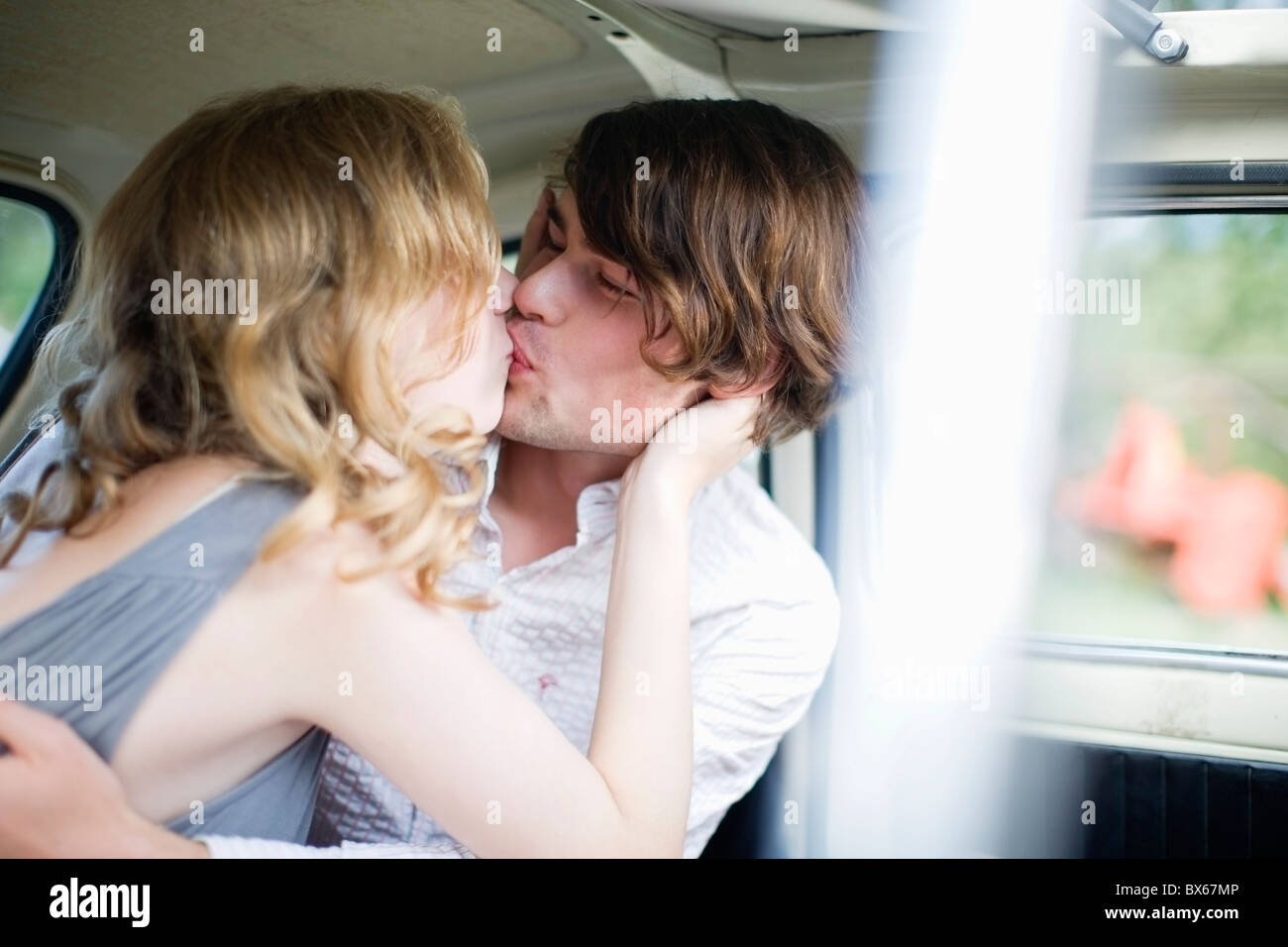 Los amantes besándose en el coche Foto de stock