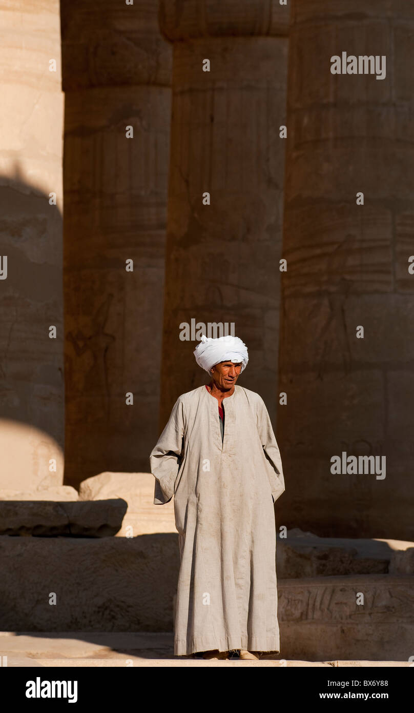 Un solitario hombre egipcio en la vestimenta sentado y vagar alrededor de los pilares ruinas del templo egipcio de Ramsés II Fotografía de stock - Alamy