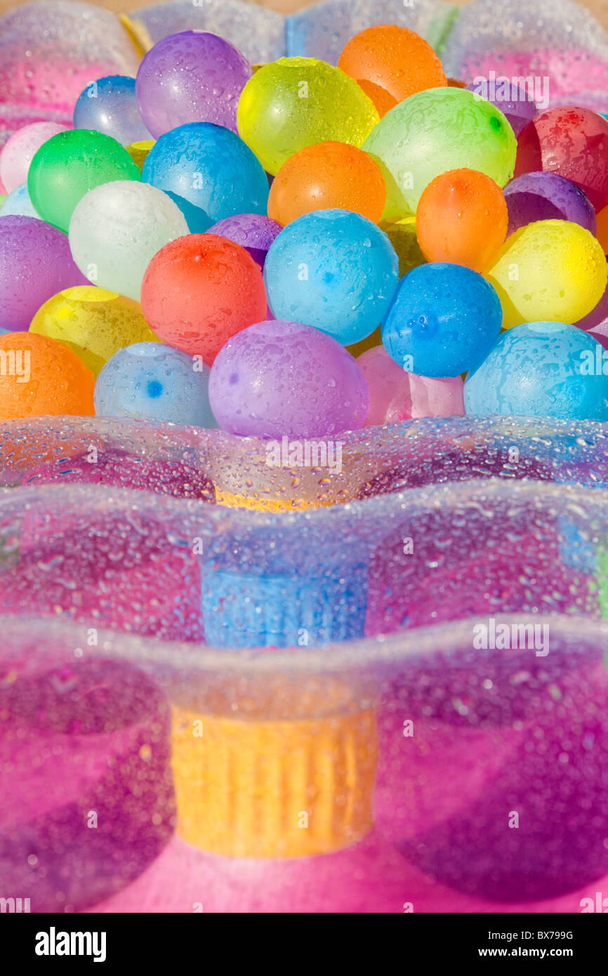 Multicolores globos de colores llenas de agua poniendo en un humedecido airbed Foto de stock