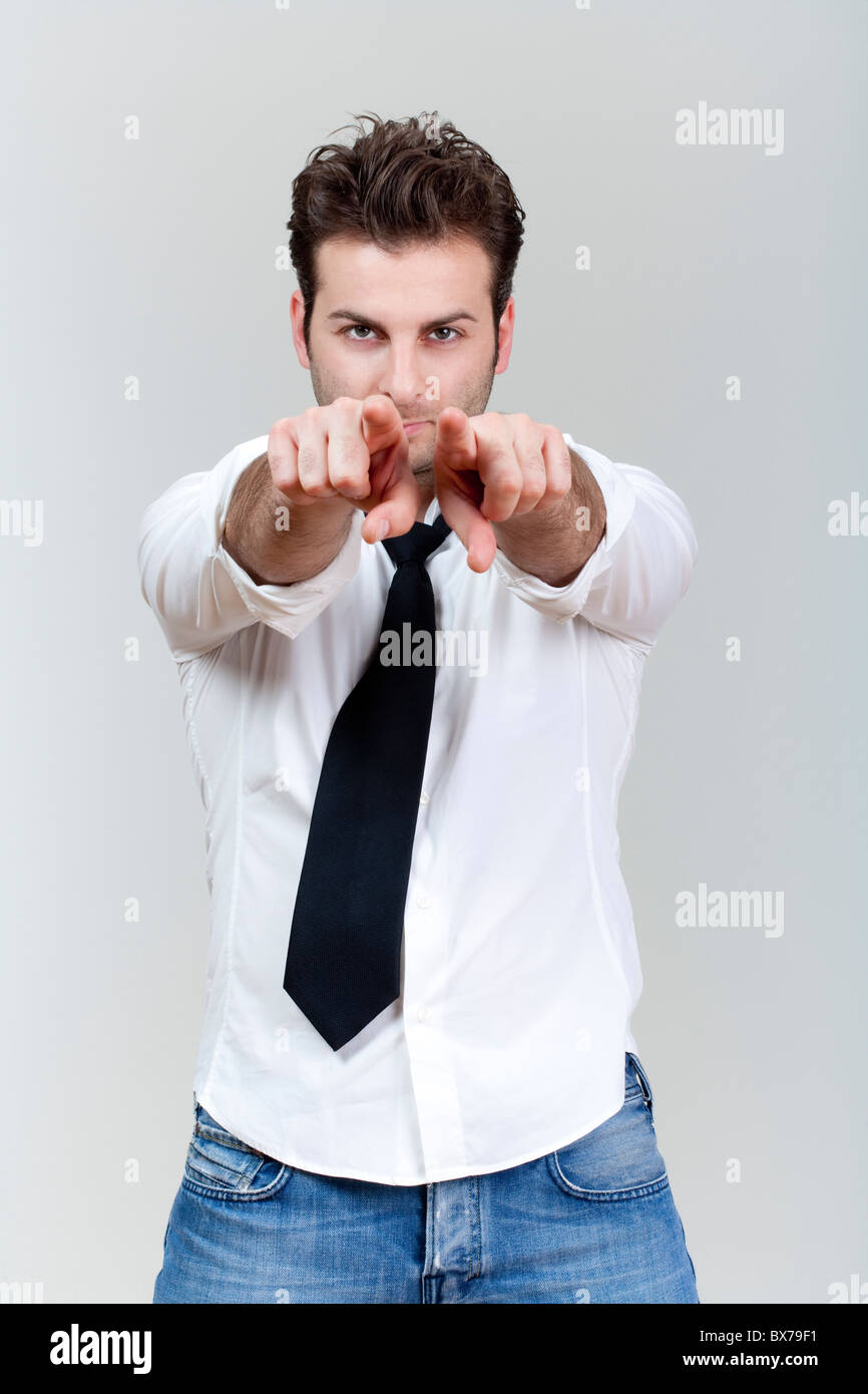El hombre con la camisa blanca y corbata con ambas manos apuntando hacia la cámara, aislado sobre fondo gris Foto de stock