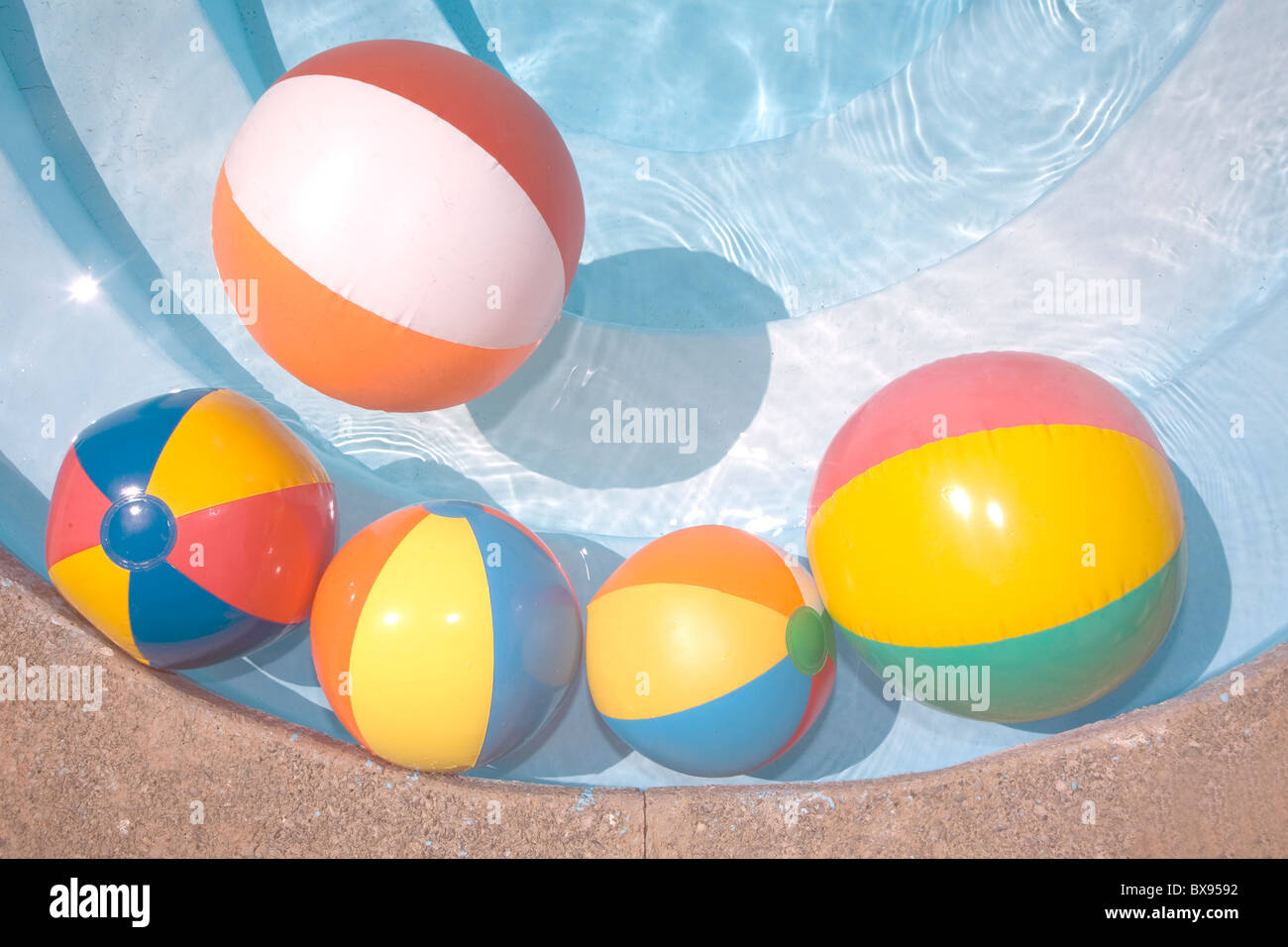 Balones de playa en una piscina de color azul Foto de stock