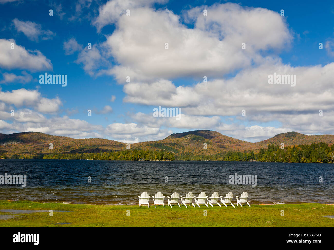 Sillas blancas en la orilla del lago de las Montañas Azules en las montañas Adirondack de Nueva York Foto de stock