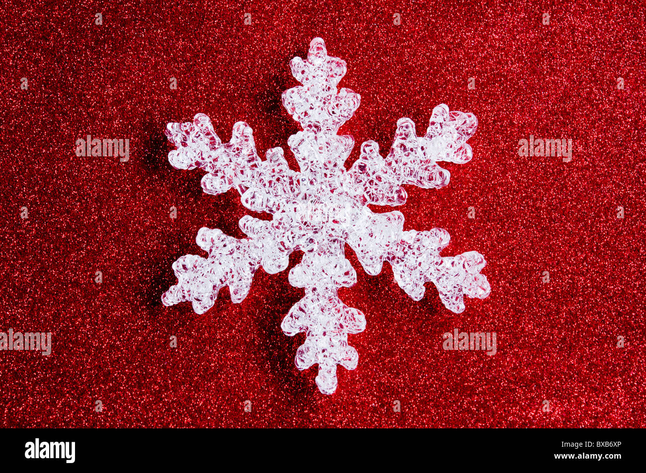 Copo de nieve con glitter rojo fondo. Foto de stock