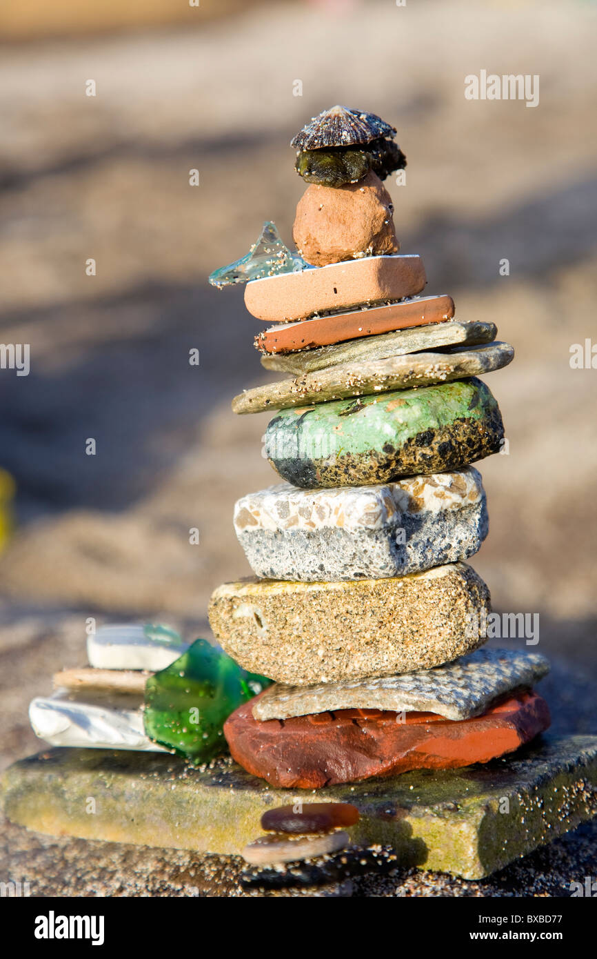 Pila de antiguos azulejos y mar de vidrio encontrados en la playa. Foto de stock