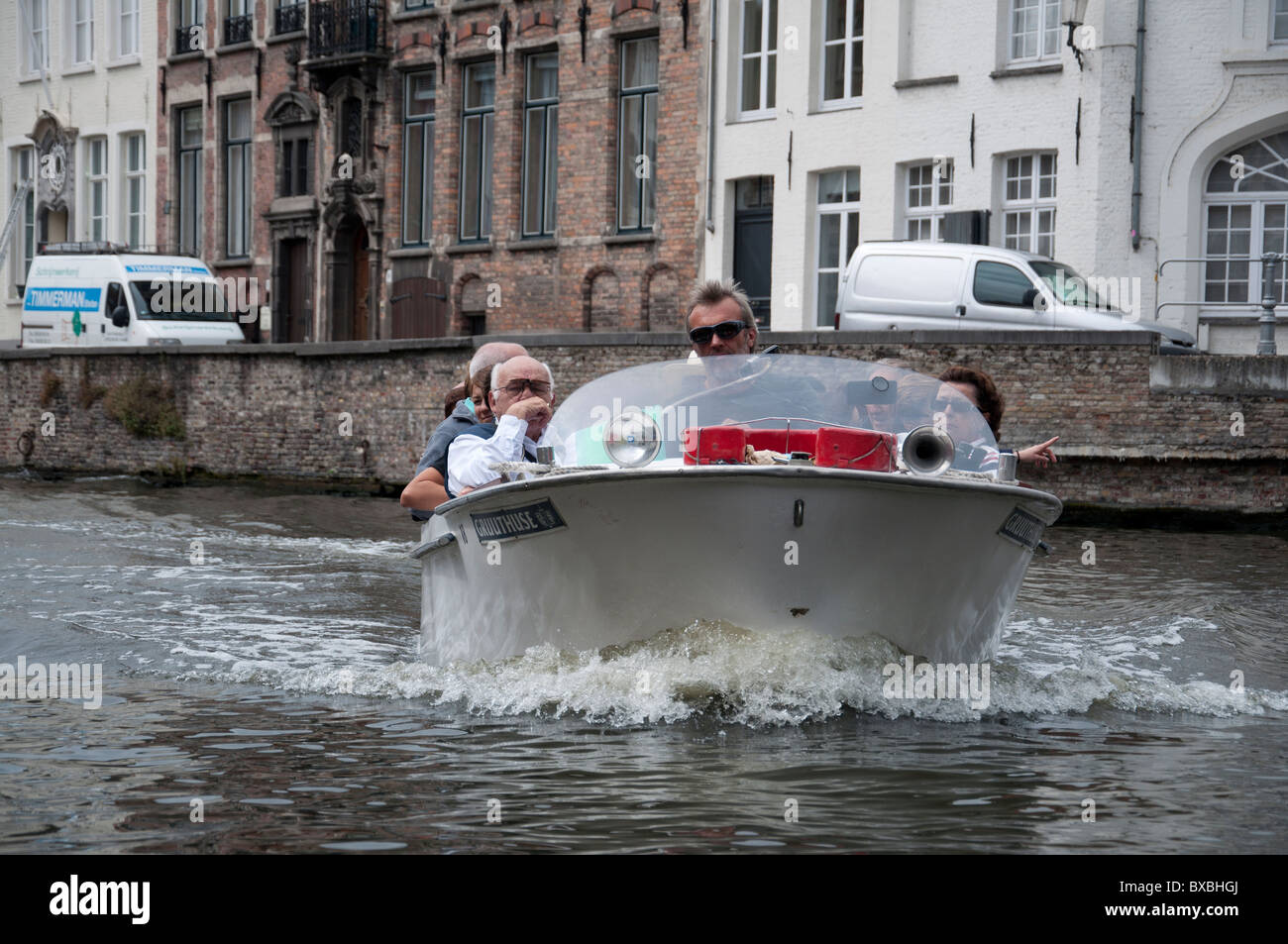 Un crucero Barco llevando pasajeros en un tour de Brujas y sus alrededores en Brujas, Bélgica. Foto de stock