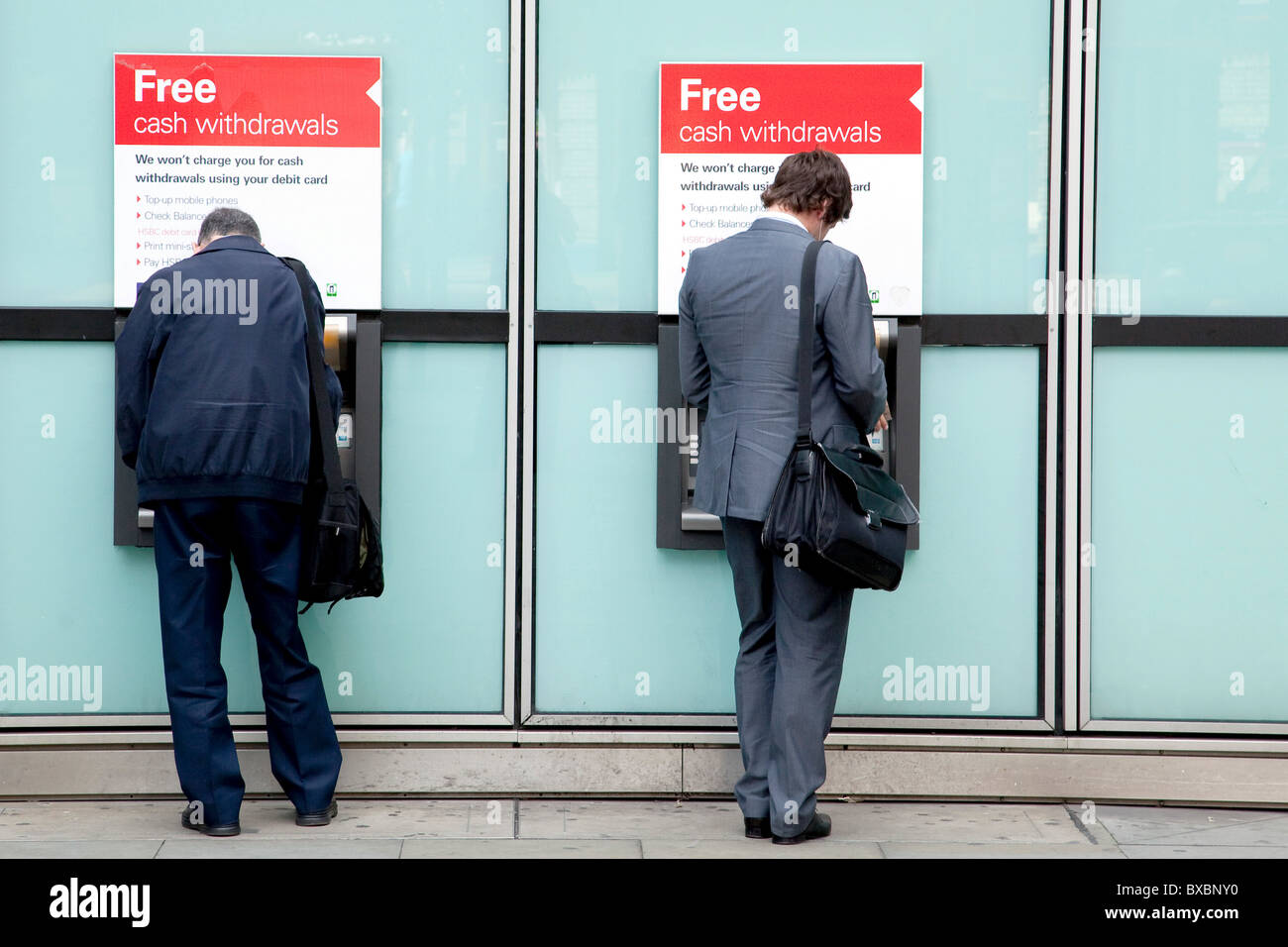 Los hombres en los cajeros automáticos del banco HSBC en Londres, Inglaterra, Reino Unido, Europa Foto de stock