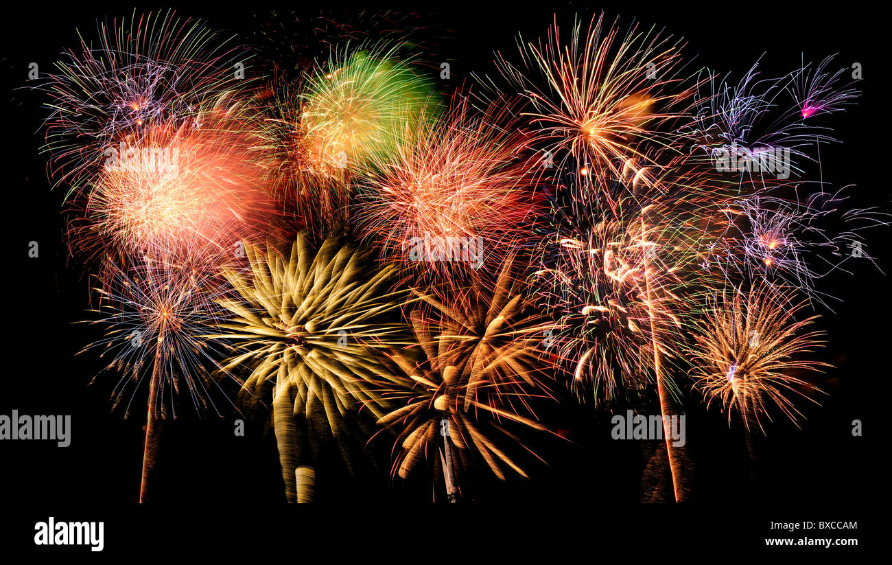 Brillantes y coloridos fuegos artificiales contra un cielo nocturno negro Foto de stock