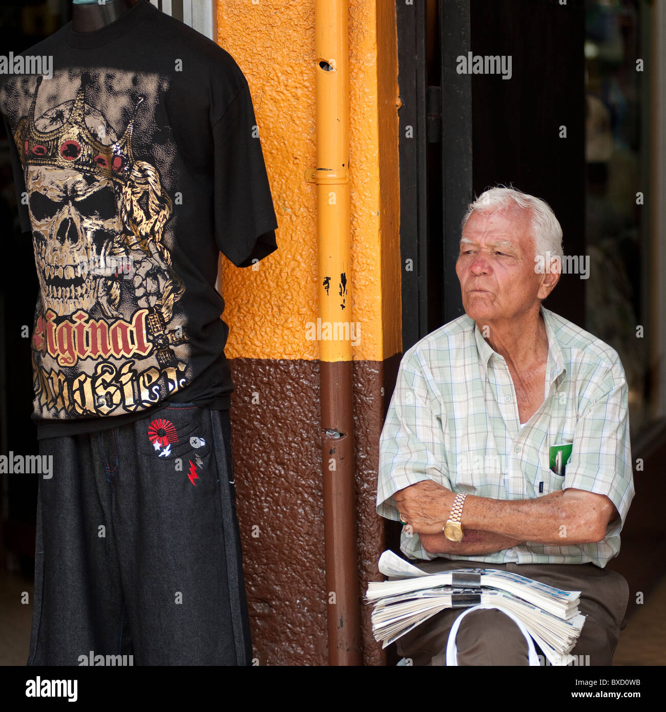 Hombre sentado en frente de una tienda en San José Costa Rica Foto de stock