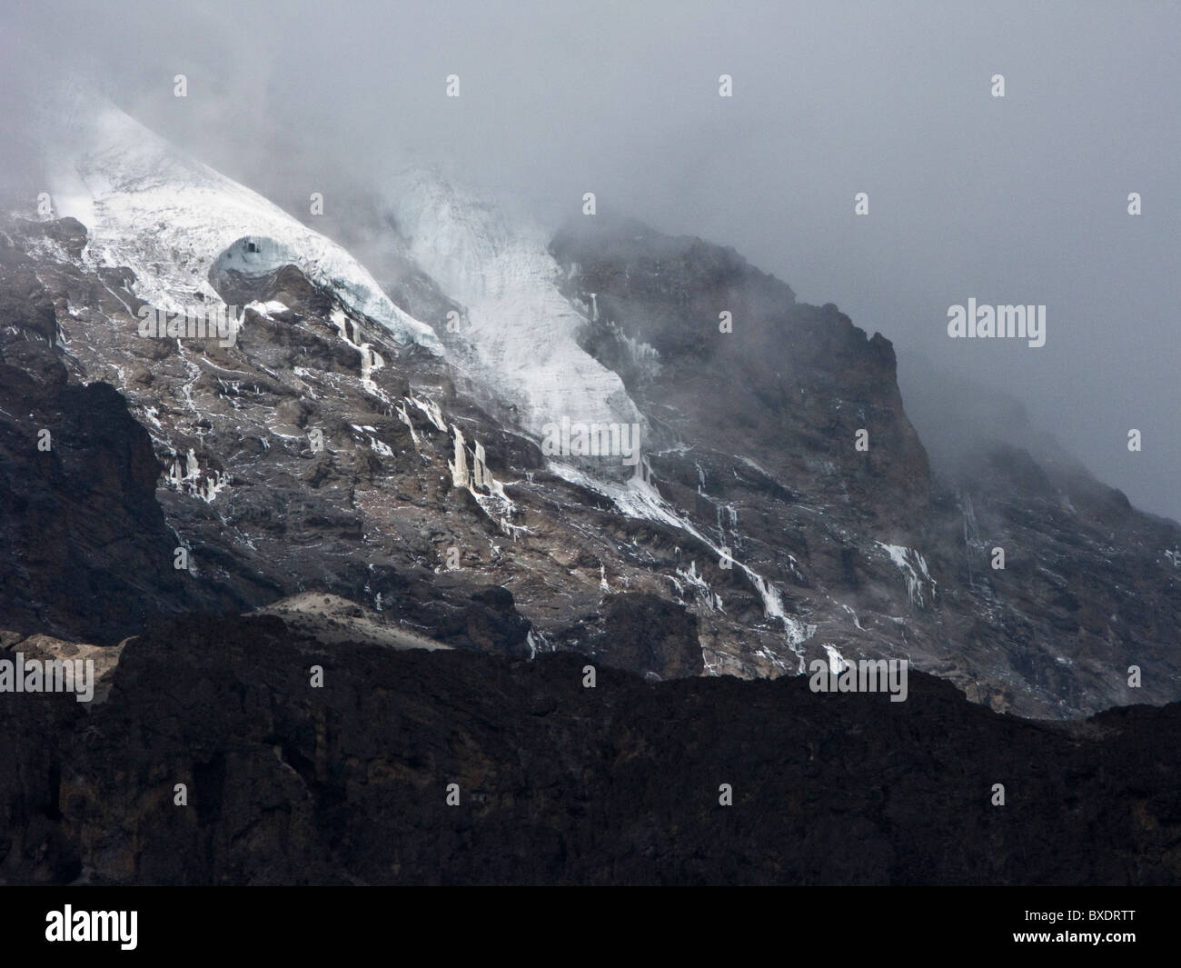 Las escarpadas, acantilados cubiertos de glaciares y la cara sur del Kilimanjaro desde un gran campamento de la expedición. Foto de stock