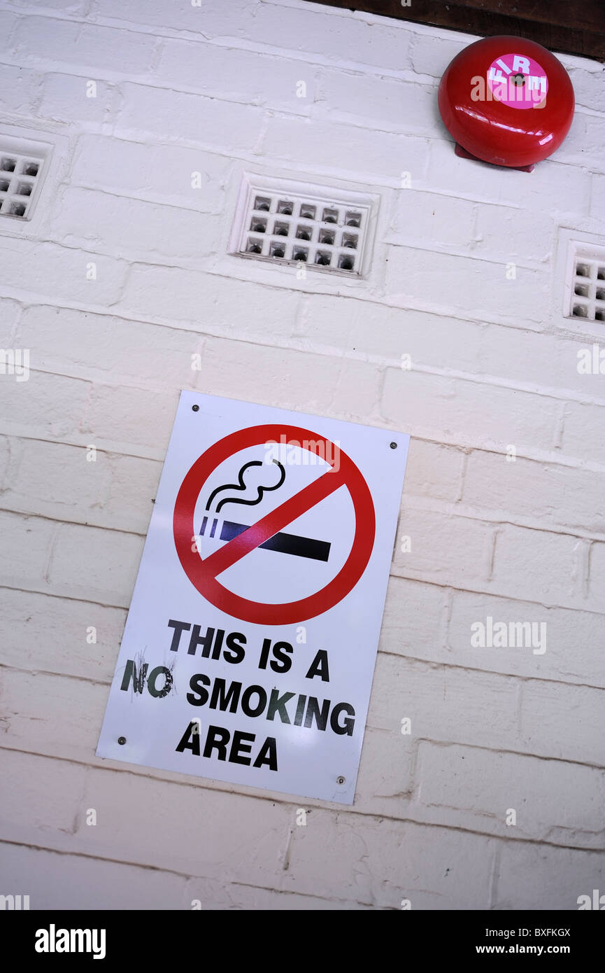 Señales de prohibido fumar cerca de la campana de alarma de incendios Foto de stock