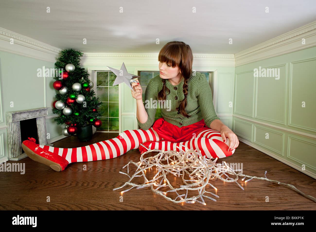 Mujer joven en una habitación pequeña con adornos de navidad Foto de stock