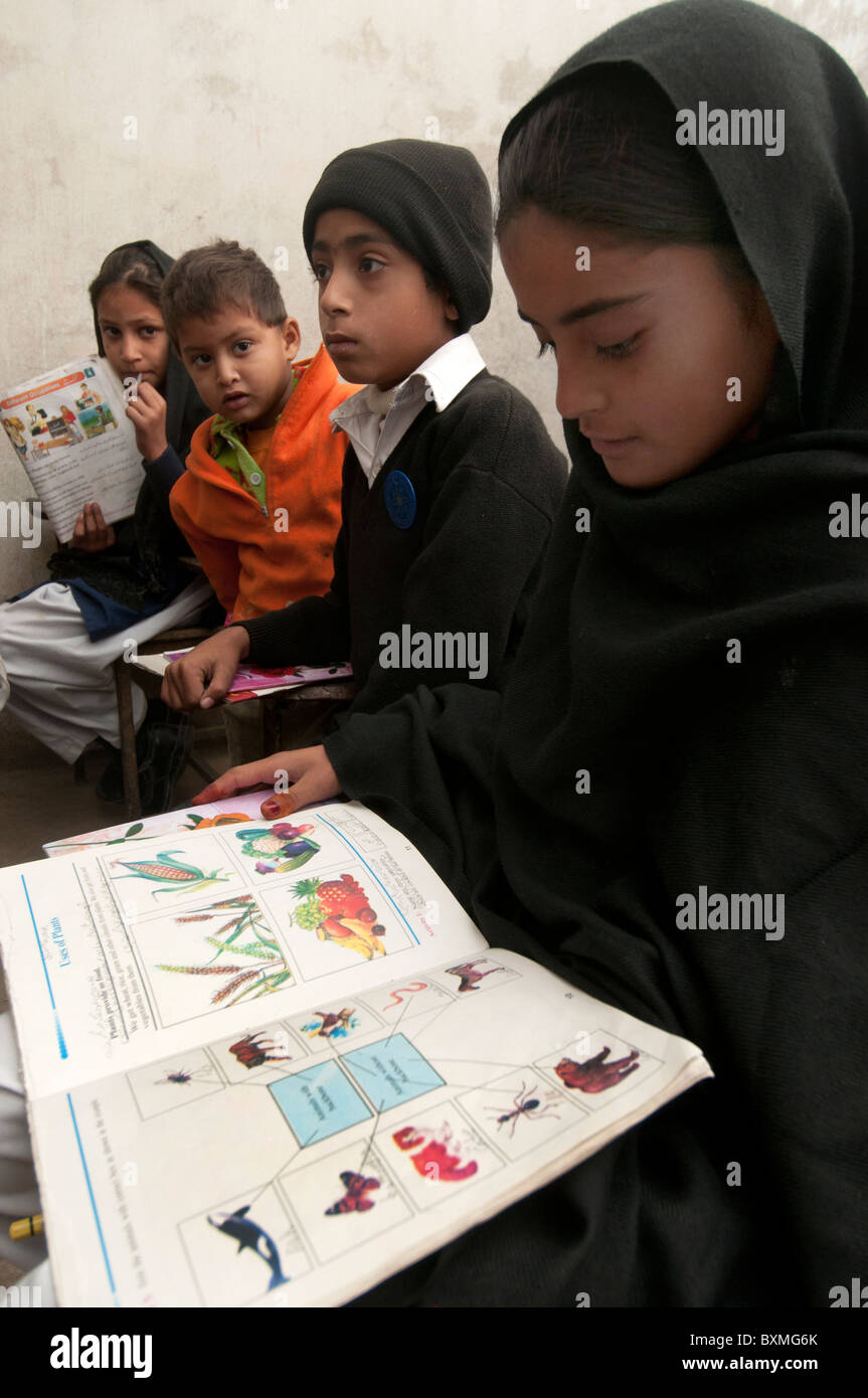 Pakistán después del diluvio.Al Haq escuela pública. Pur Risal zona. 230 alumnos, 9 profesores.Los alumnos leer libros donados Foto de stock