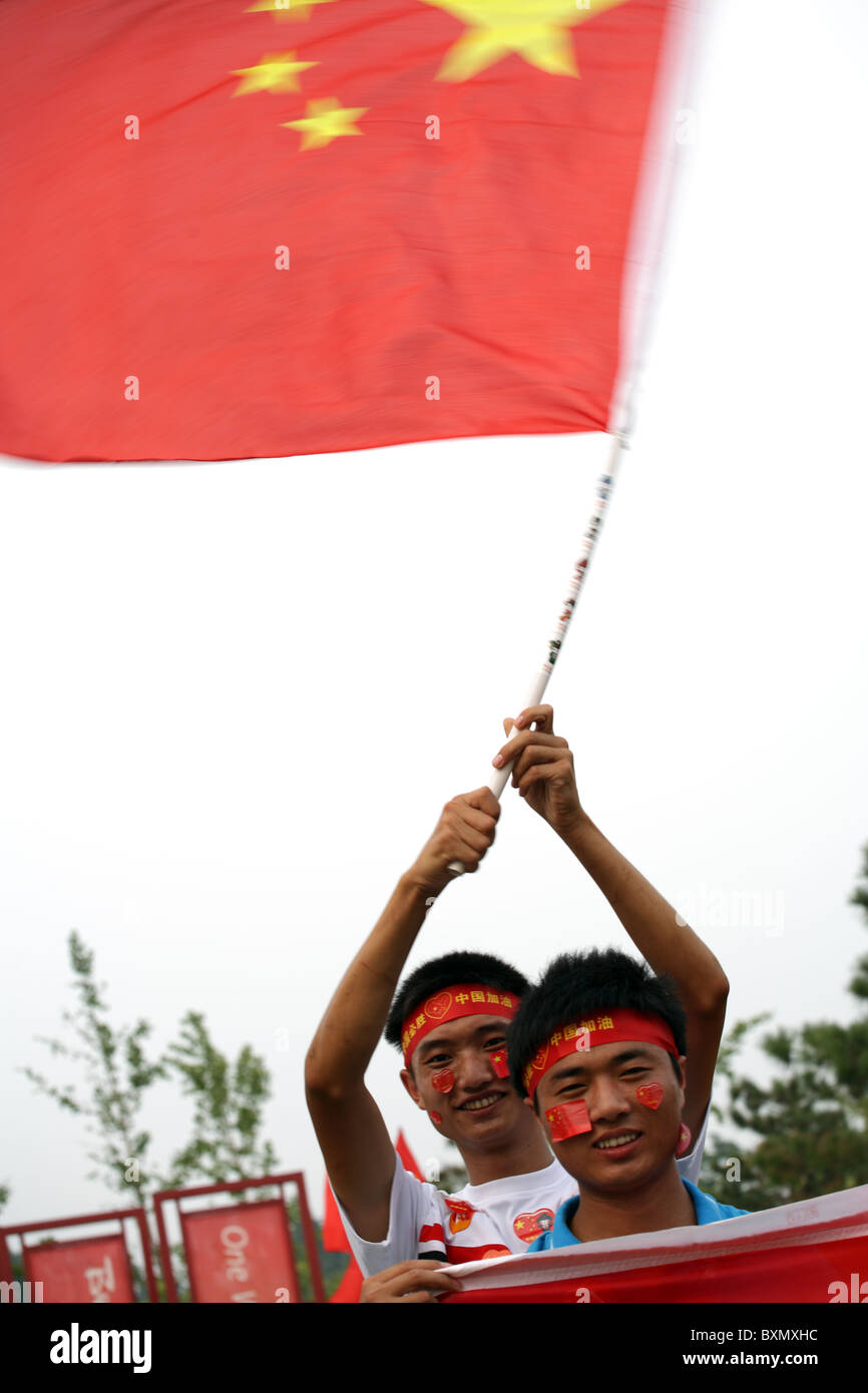 Hombres chinos ondeando la bandera de China, Desfile de Juegos Olímpicos, Beijing, China Foto de stock