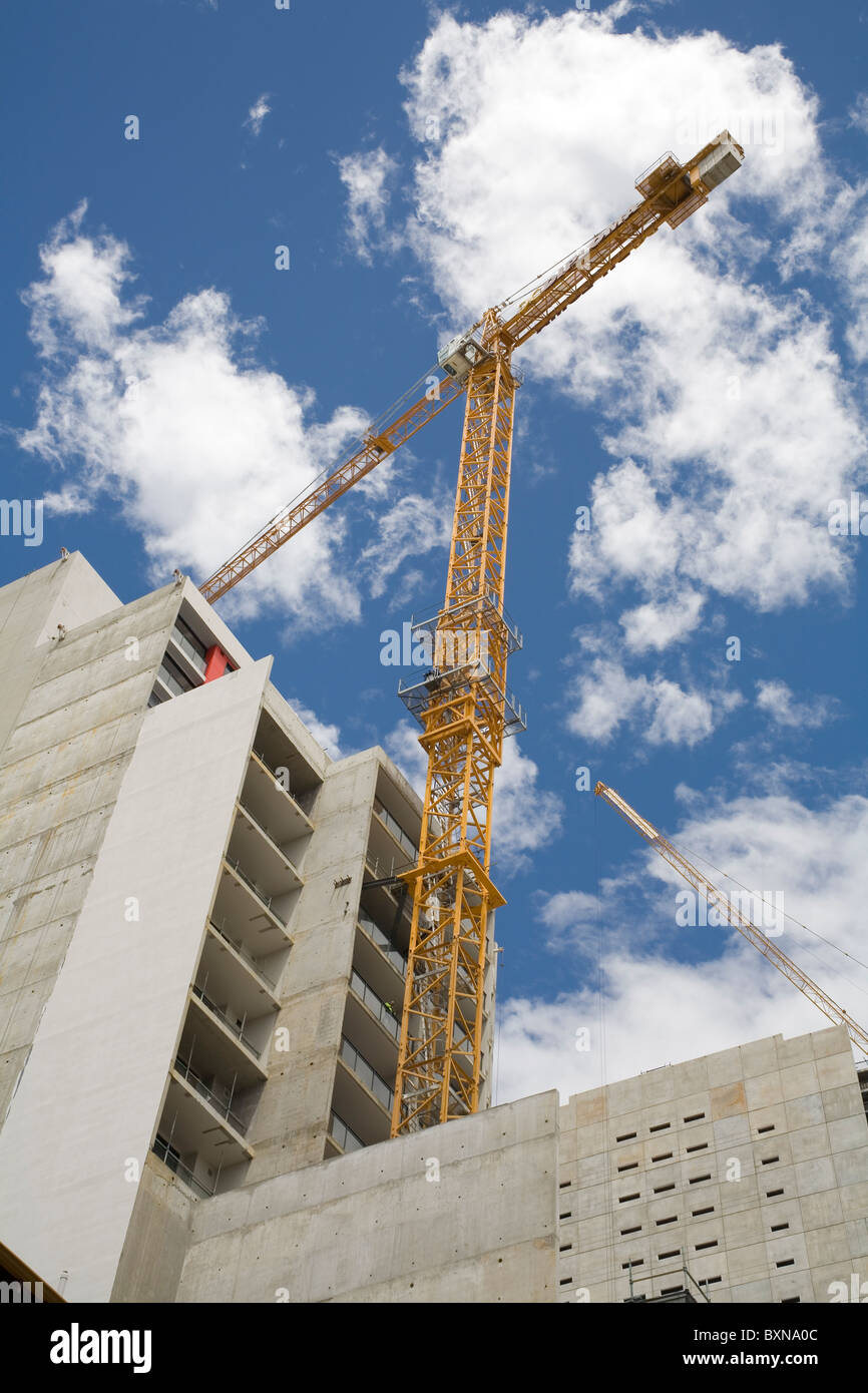 Estiramiento de la grúa hacia el cielo en un sitio en construcción Foto de stock