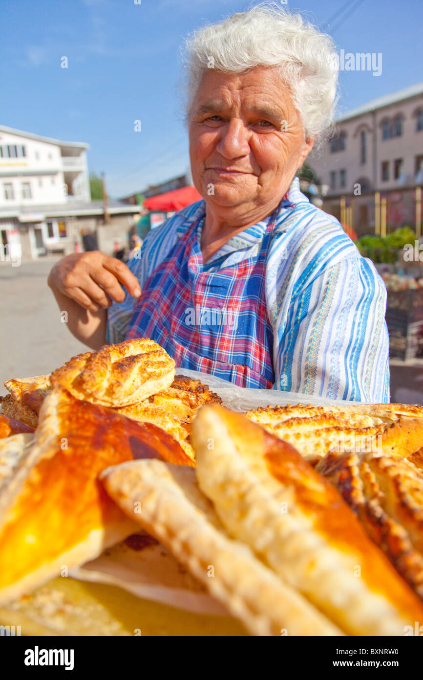 Mujer vendiendo pasteles en un mercado de alimentos o Shuka en Vanadzor Armenia Foto de stock