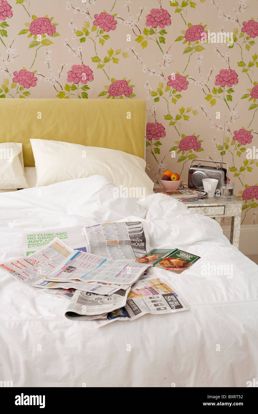 Cama desordenada con cubiertas en periódicos Foto de stock