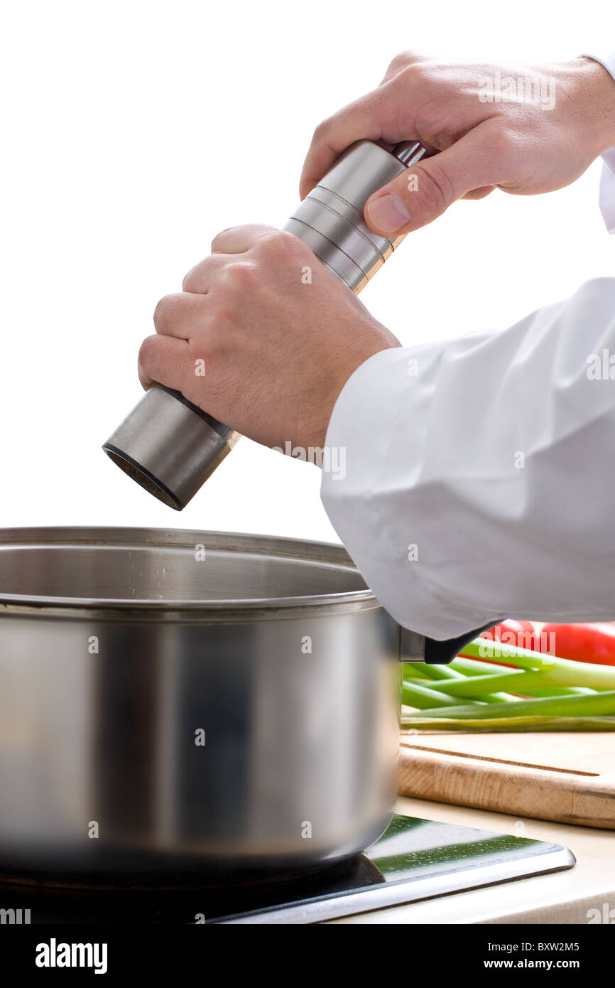 Chef añadir pimienta molida para comida preparada Foto de stock