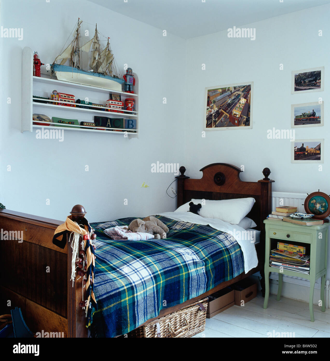 Plaid azul alfombra y ropa blanca de cama de madera antigua en blanco del  niño dormitorio con modelo de barco en la pequeña unidad de estante de  pared Fotografía de stock -