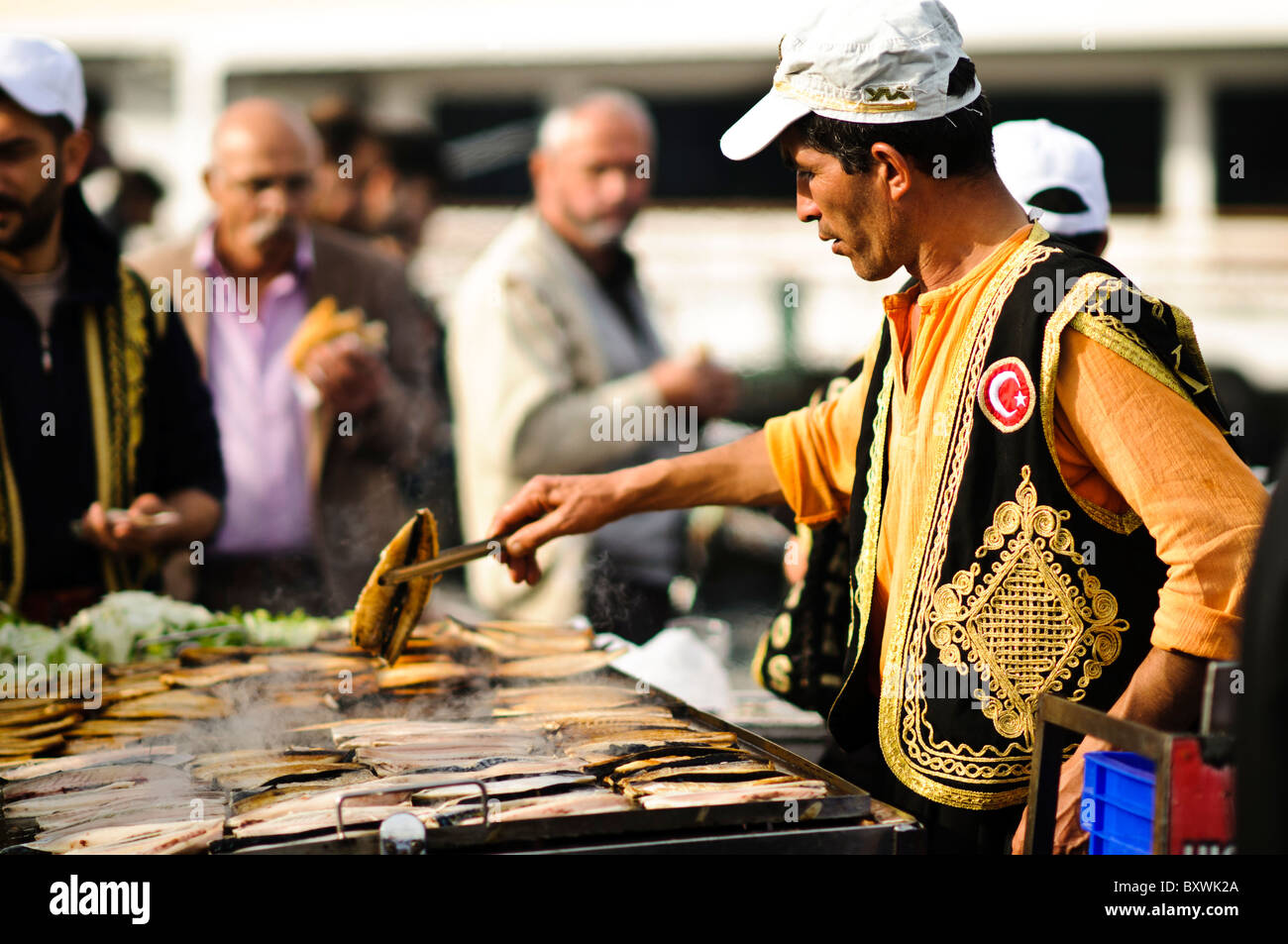Cocinar el pescado en una parrilla abierta en la costanera de Eminonu en Estambul, cerca del puente de Galata el Cuerno de Oro. Foto de stock