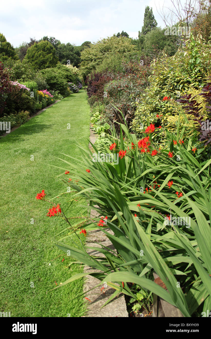 Jardines Walkden, venta, Inglaterra. Pintorescas vistas de los Jardines Walkden fronteras con montbretia fuera de foco en el primer plano. Foto de stock