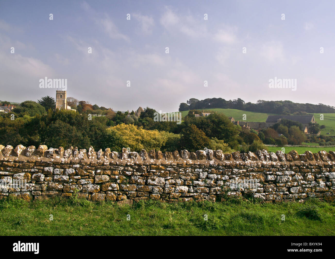 Escena típica campiña inglesa, con un antiguo muro de piedra, coloridos árboles y una antigua abadía rural Foto de stock
