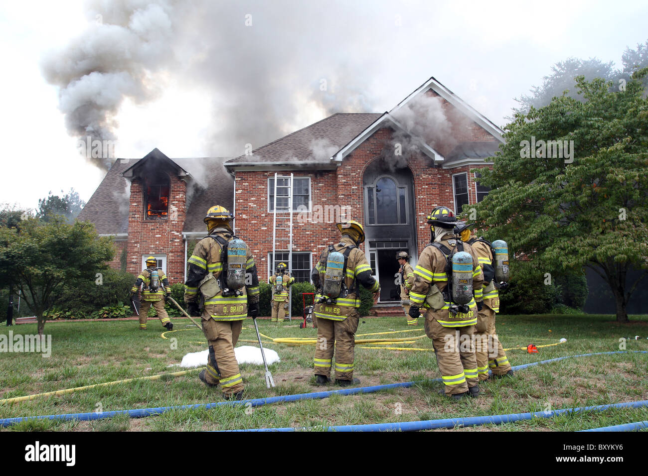 Los bomberos sacan un incendio en una casa de 2 pisos. Foto de stock