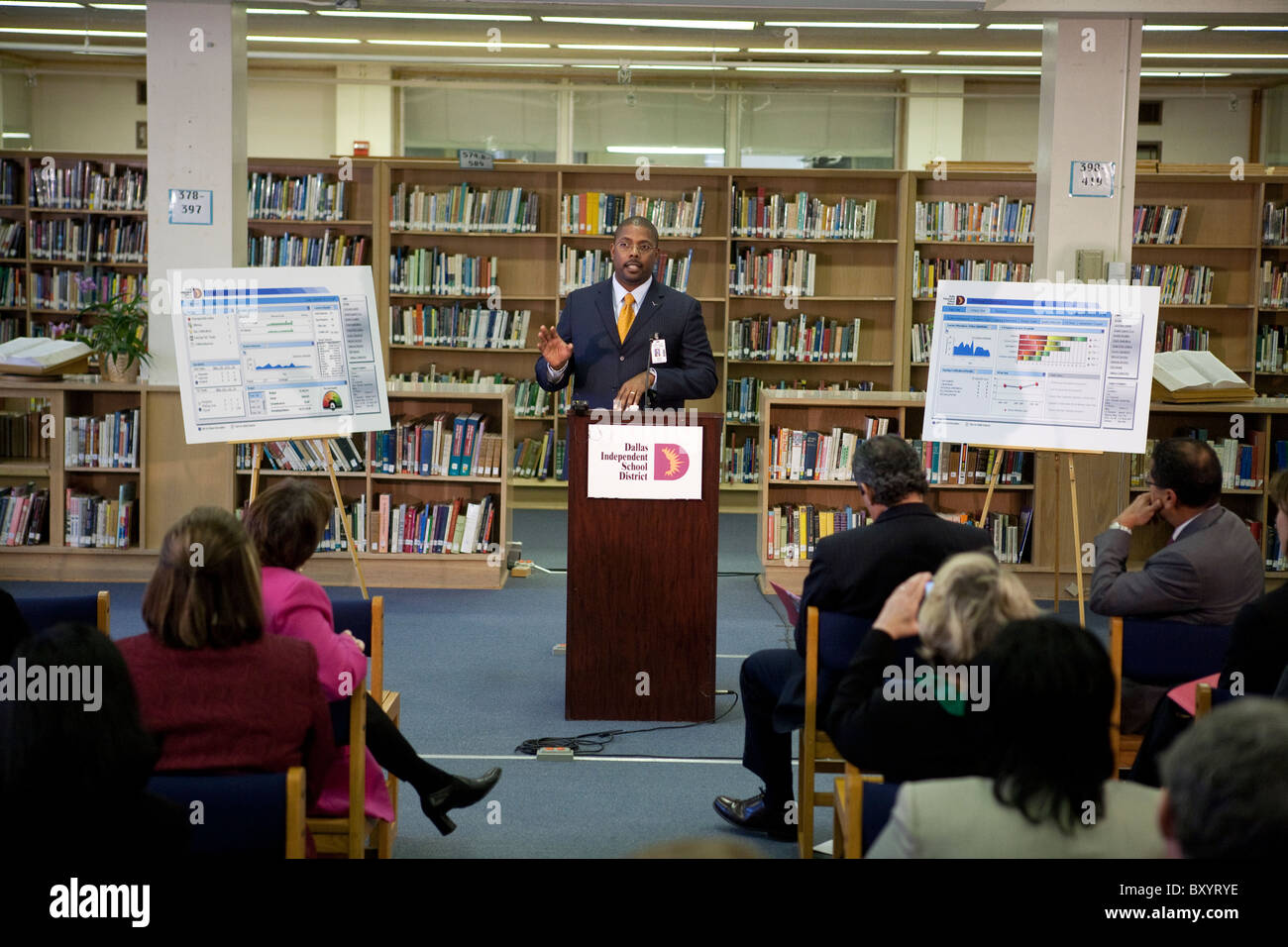 Macho americano africano ejecutivo de la organización sin ánimo de lucro hace presentación durante una conferencia de prensa en la biblioteca de la escuela pública Foto de stock