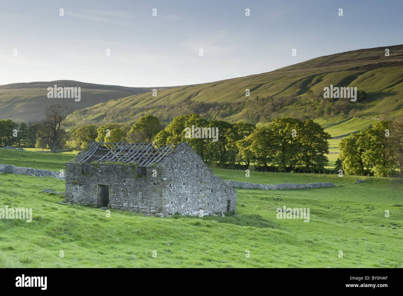 Ruinas de granero de campo de piedra, ladera escénica del valle de la colina, tierras de cultivo y colinas altas iluminadas por el sol - Arncliffe, Littondale, Yorkshire Dales, Inglaterra, Reino Unido Foto de stock