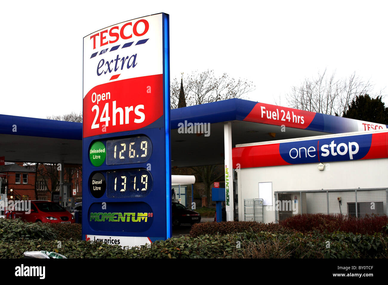 Tesco Extra estación de combustible abierta las 24 horas del día, mostrando el precio de la gasolina en el garaje después de la subida del IVA Foto de stock