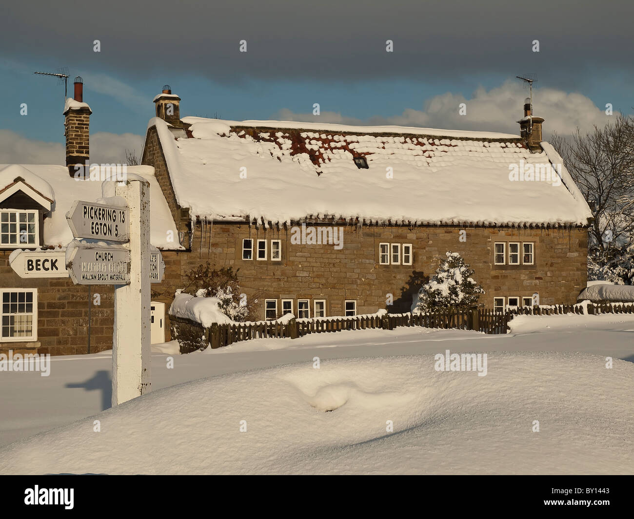 Cottage y el cartel en nieve profunda Goathland, North Yorkshire. Foto de stock