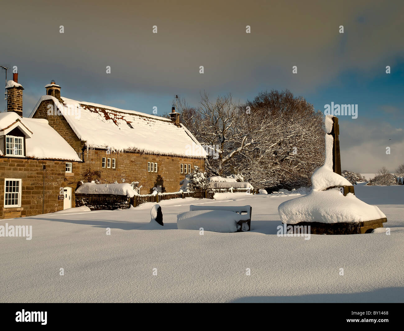 Cottage y War Memorial en nieve profunda en Goathland, North Yorkshire. Foto de stock