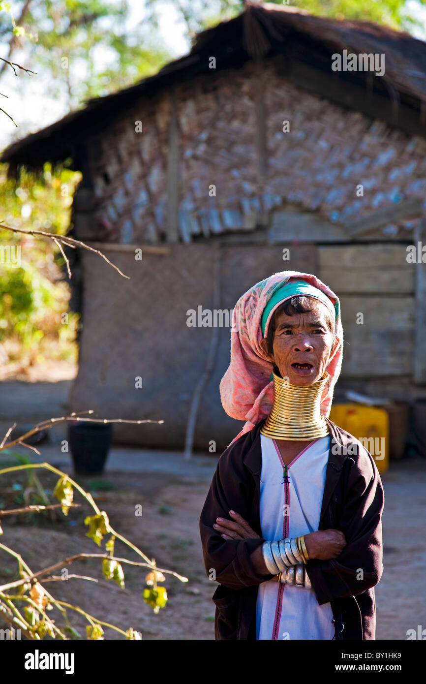 Myanmar, Birmania, Loikaw. Una Padaung (cuello largo) mujer de pie fuera de su casa, vestida con su tradicional bobinas, el cuello de latón Foto de stock