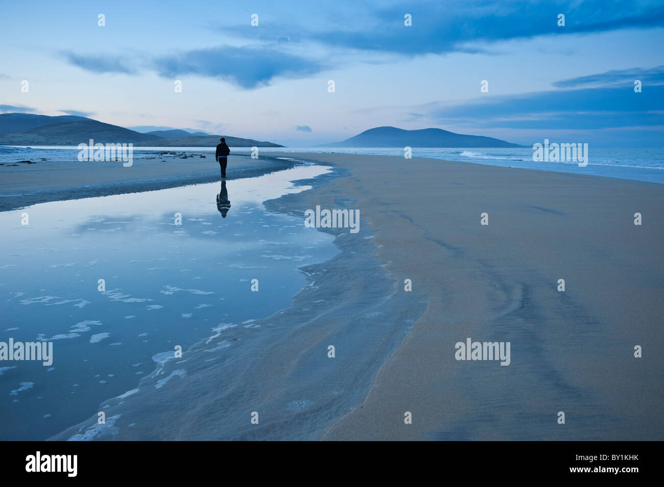 La reflexión de la persona caminando en Luskentire beach, en la isla de Harris, Western Isles, Escocia Foto de stock