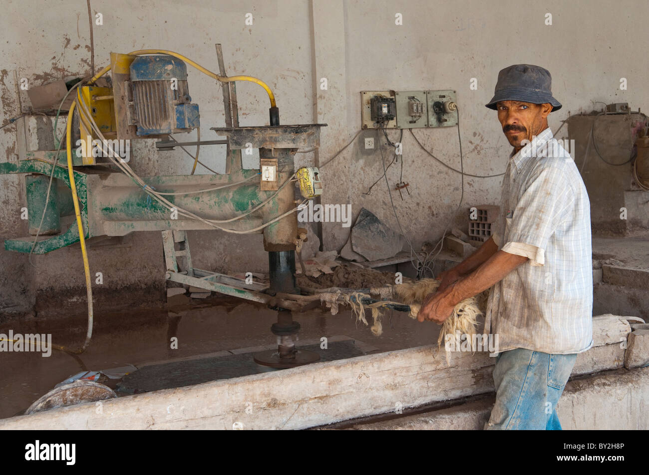 Un trabajador de la fábrica de fósiles de Macro cerca de Erfoud, Marruecos. Foto de stock