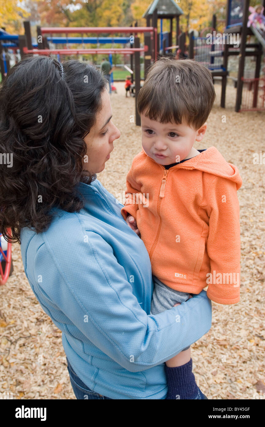 Hispanic dos años es consolado por su madre en el parque modelo liberado. Foto de stock