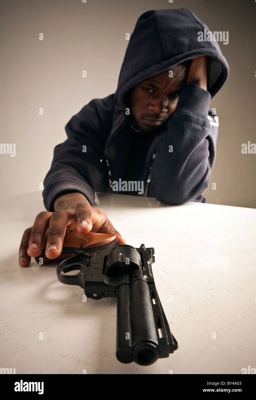 Joven negro modelo masculino posando con una pistola Foto de stock