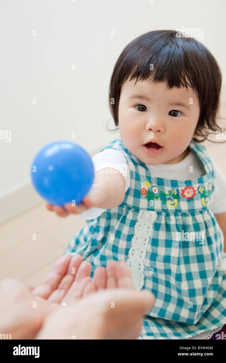 Chica dando bola a la madre Foto de stock