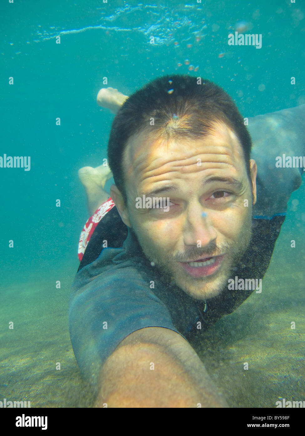 El hombre bajo el agua en busca de agua arenosa pulpo Foto de stock