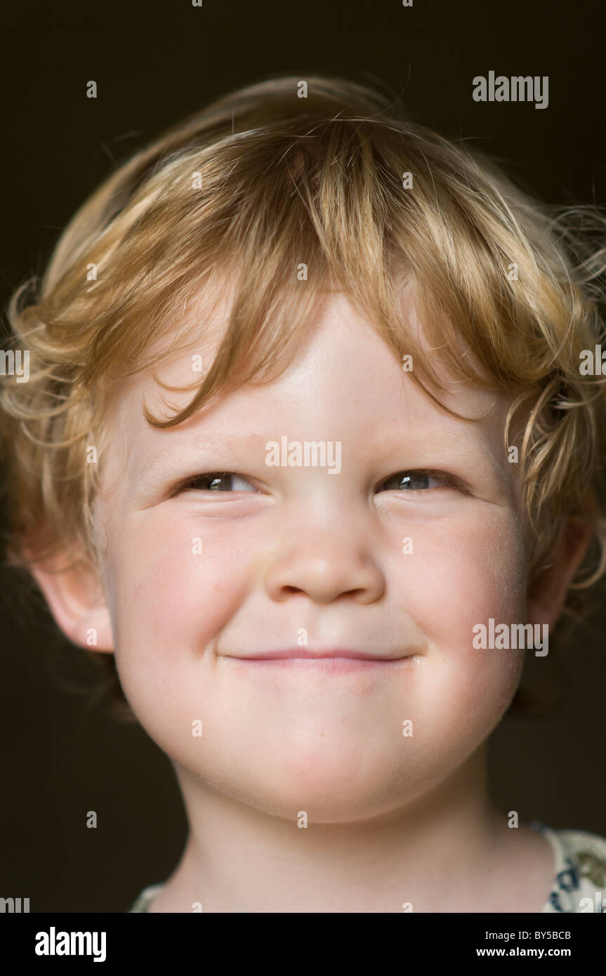 Retrato de un niño de dos años captando su impertinente sonrisa Foto de stock